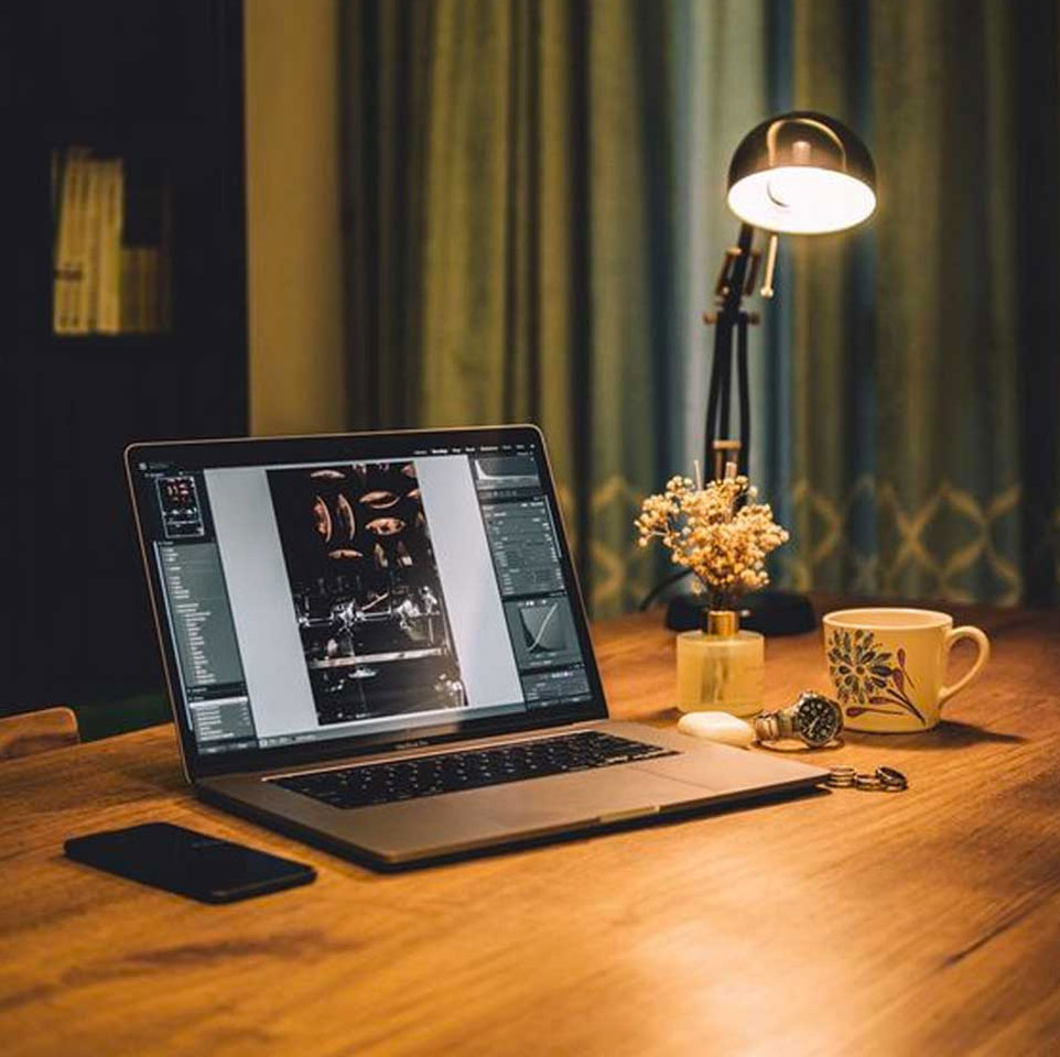 Lisa Jacobi Design Mobile Slide desktop computer on a desk at night illuminated by a lamp